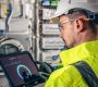man-electrical-technician-working-switchboard-with-fuses-uses-tablet-2-scaled